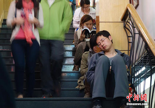 资料图：2014年4月10日，已近午夜，位于北京美术馆东街的三联韬奋书店内灯火通明，顾客络绎不绝，书店还为顾客提供了桌椅台灯方便阅读。这家已有20余年历史的书店成为北京尝试24小时开放的书店之一。中新社发 杜洋 摄