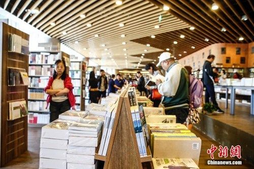 资料图：4月23日正值世界读书日，在北京三联韬奋24小时书店成立一周年之际，三联第二家24小时书店海淀分店正式开业。新书店占地面积大于老店，实际图书区域达500多平方米，虽只有一层，但座位充足，爱书人可以充分享受一个夜晚的阅读时光。书店一侧还有咖啡、甜品和简餐售卖。中新社发 张浩 摄
