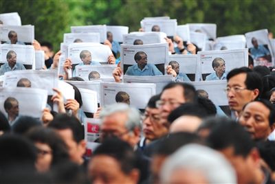 前来送别陈忠实的群众，有人手举手写书法，有人高举印有陈忠实纪念专号的报纸(图)。 图/视觉中国